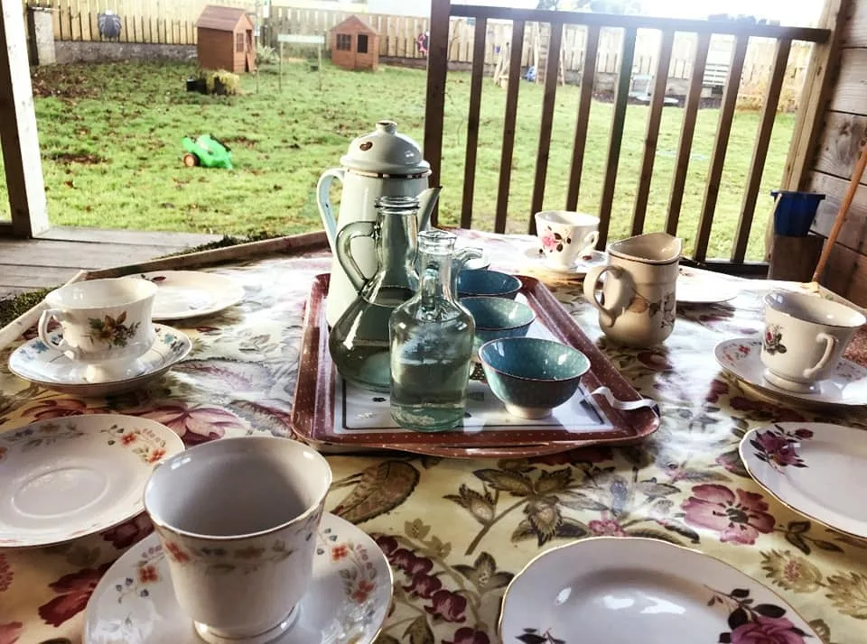 A tea set arranged on a table in the wooden garden shelter