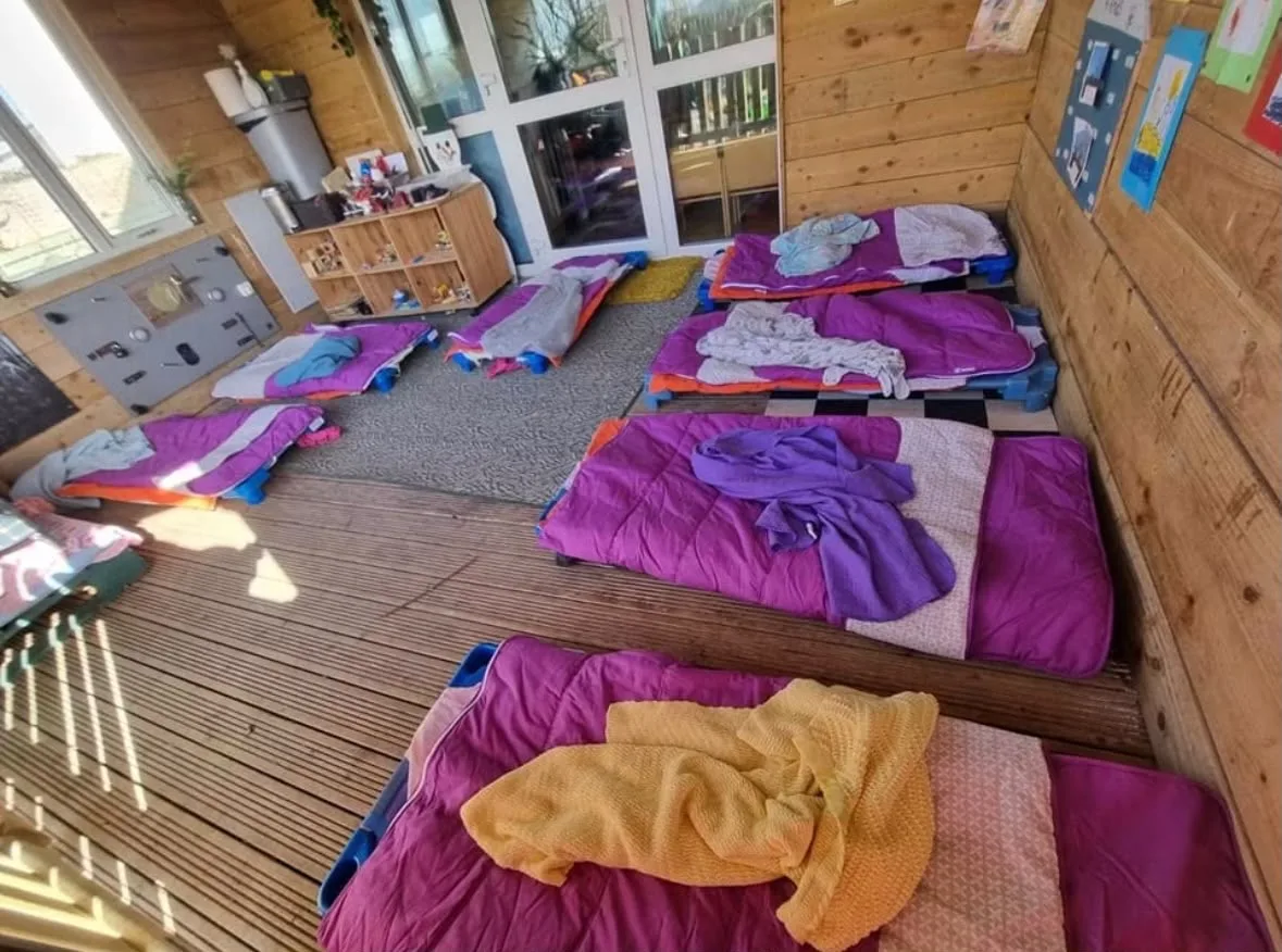 Sleeping mats and blankets arranged inside the wooden room