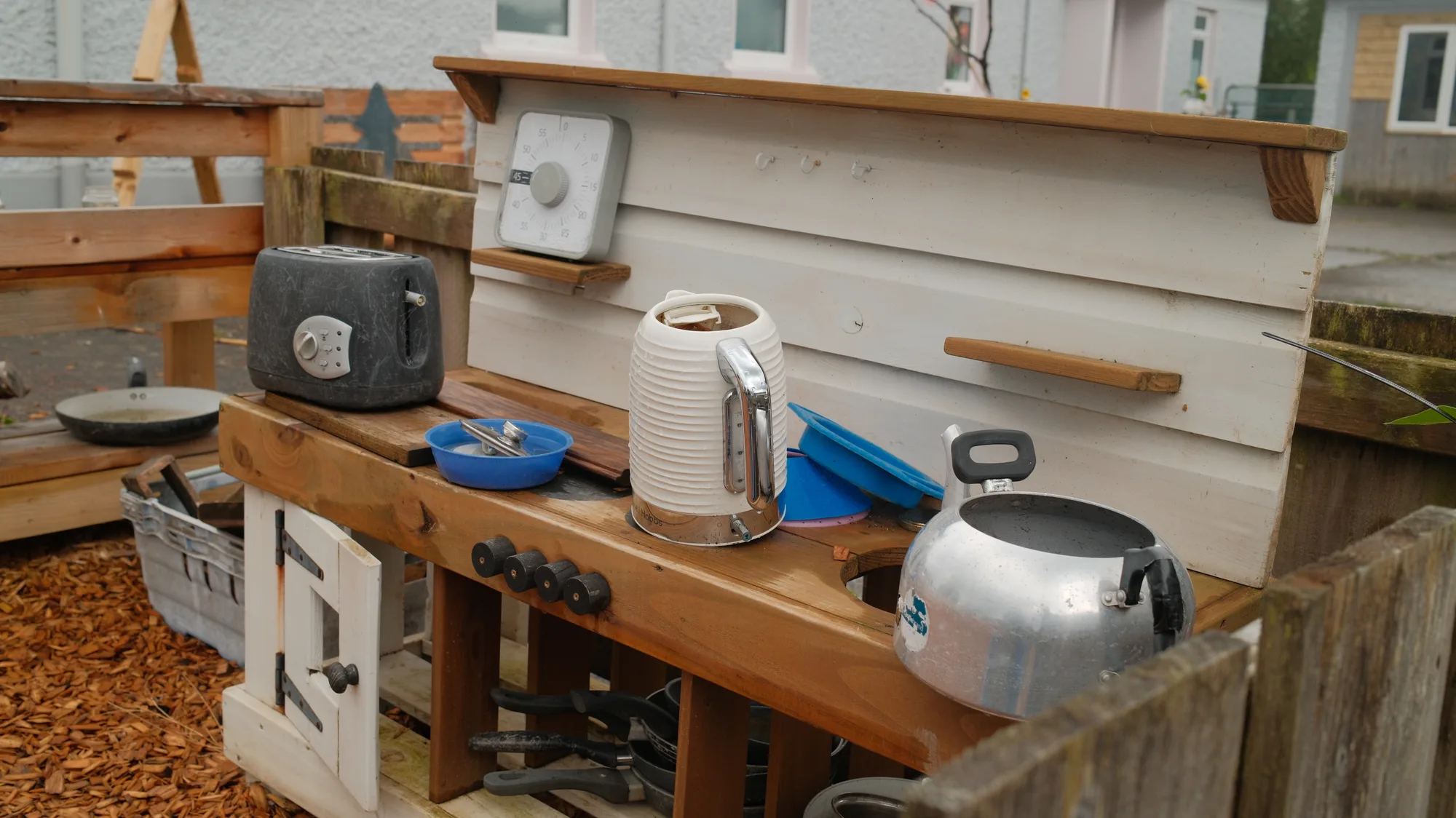 Kettles, pots and cups on the outdoor kitchen shelves