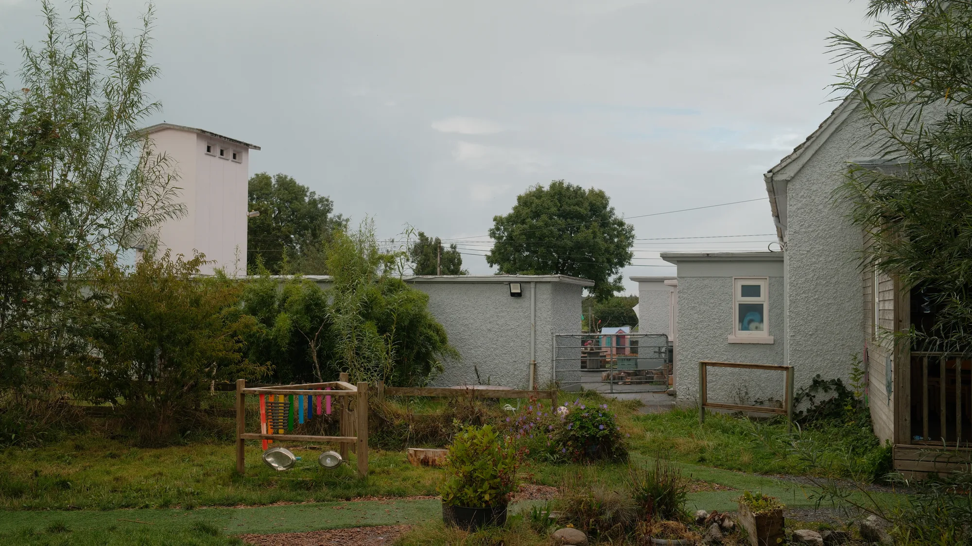The white building seen across the planted garden