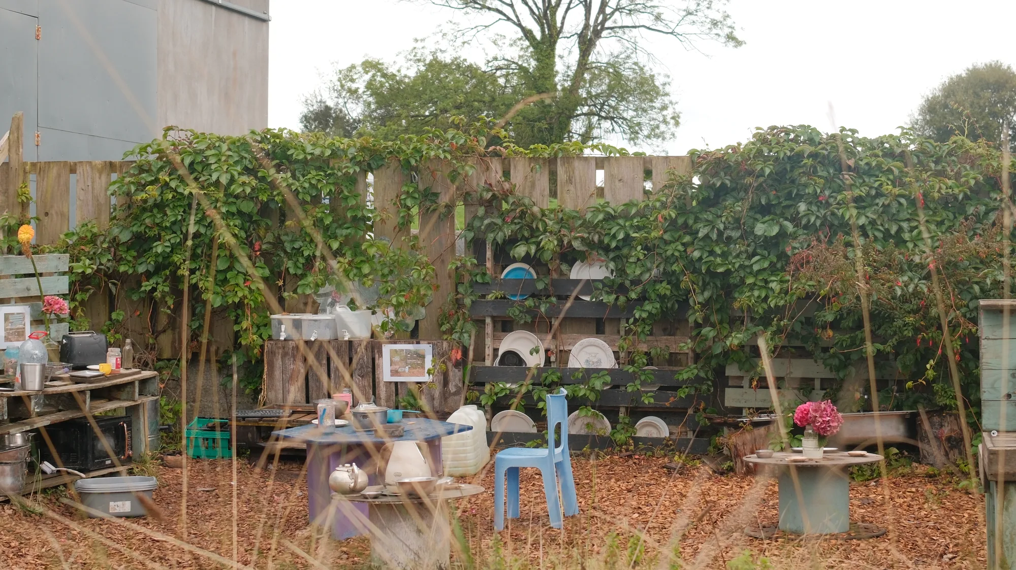 Outdoor tables, chairs and play materials in the mud kitchen.