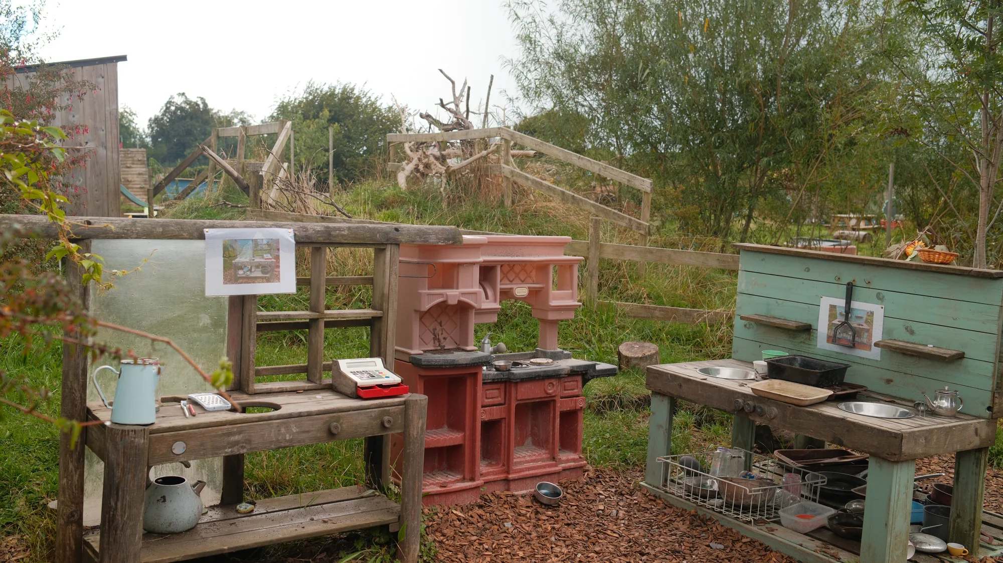 Two mud kitchens set side by side outdoors
