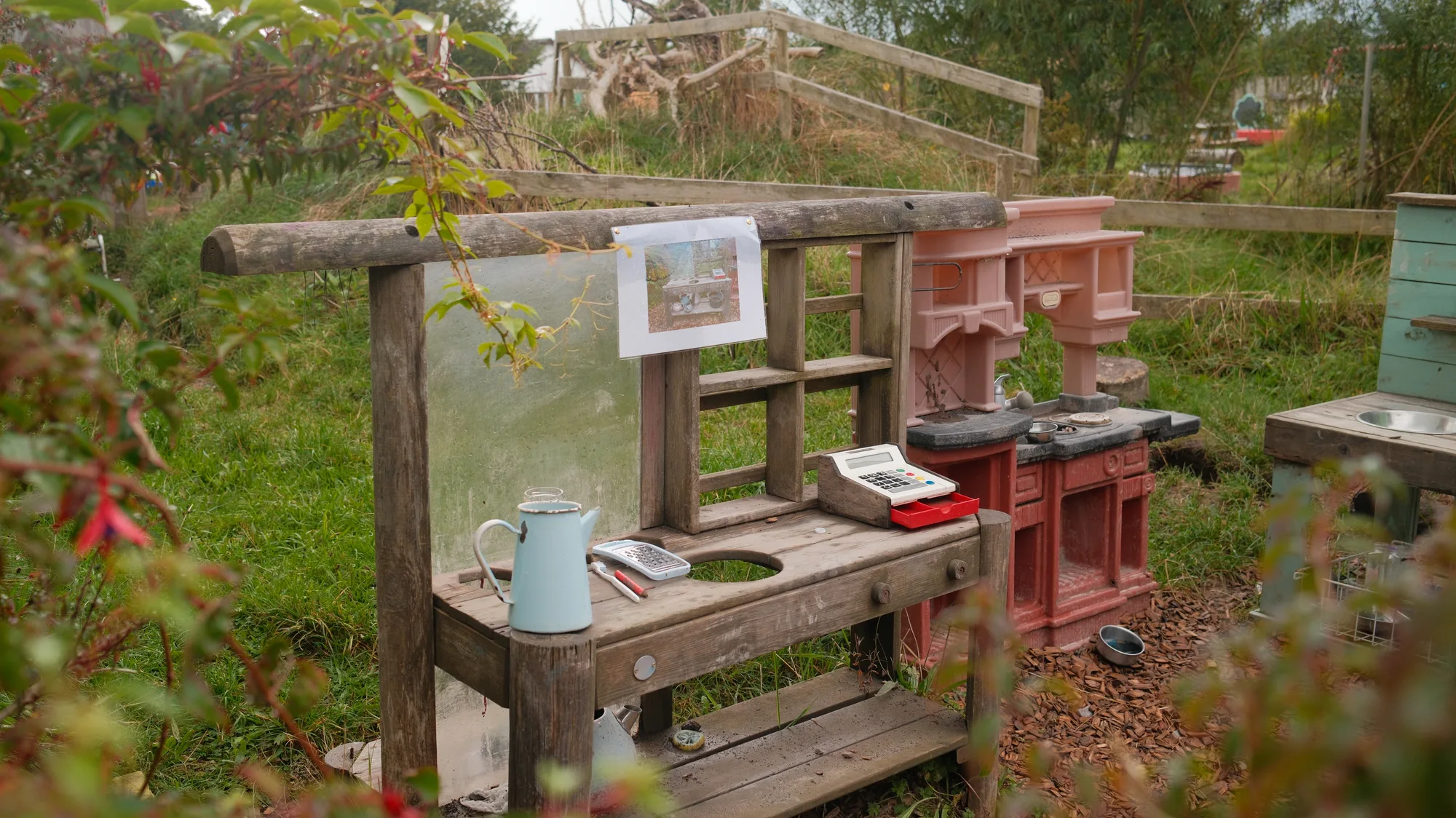 Outdoor kitchen benches beside a planted border