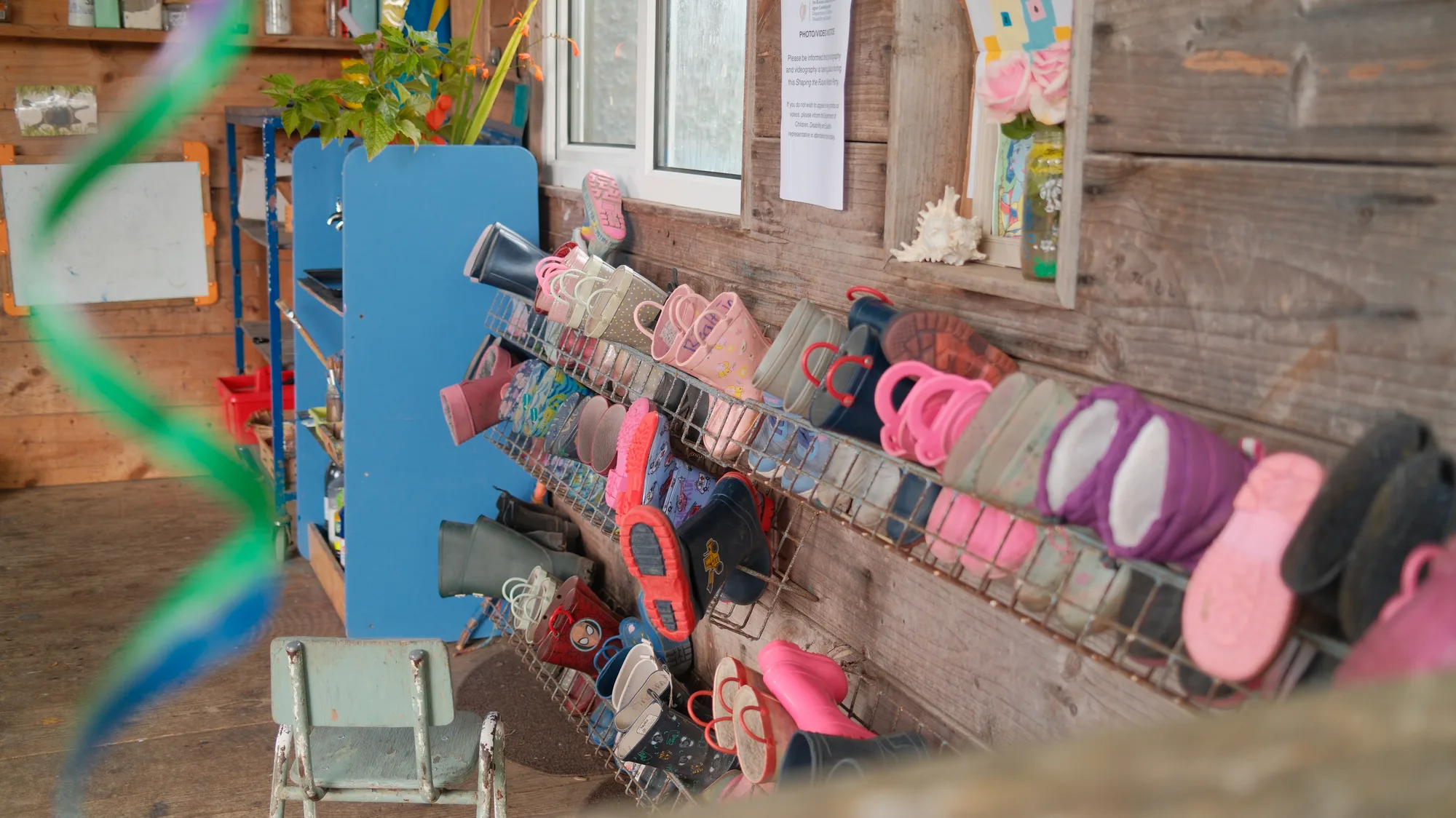 Colourful wellies stored along the shelter wall
